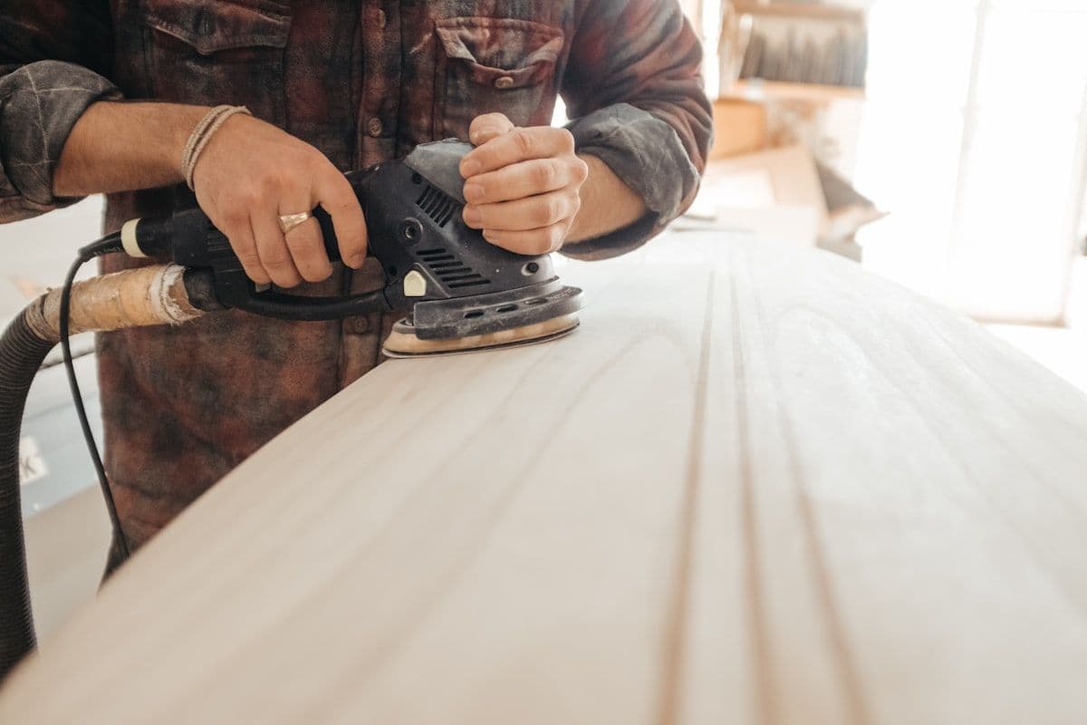 Craftsman's hands sanding raw wood