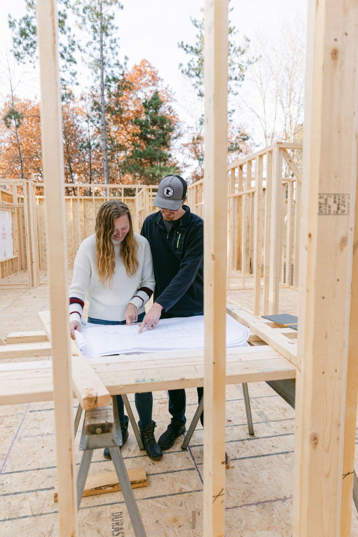 Client and tradesperson reviewing building plans together on site